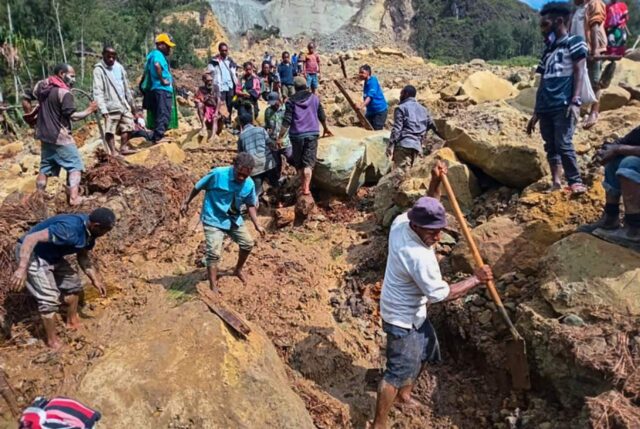 Warga desa mencari melalui tanah longsor di Desa Yambali di Dataran Tinggi Papua Nugini, Ahad, 26 Mei 2024. | Mohamud Omer/International Organization for M