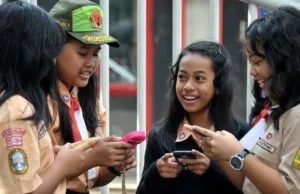 Melindungi Anak Indonesia Dari Jebakan Media Sosial Anak-anak sekolah di Indonesia membuka Facebook di perangkat seluler mereka. Sumber Getty Images
