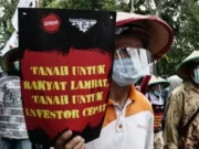 Tok! DPR RI Sahkan RUU Reforma Agraria Jadi Undang-undang Seorang demonstran saat aksi protes terhadap UU Cipta Kerja 2020 silam membawa tuntutan reforma agraria. Sumber: Anadolu Agency via Getty Images