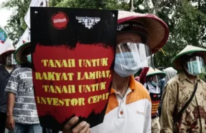 Tok! DPR RI Sahkan RUU Reforma Agraria Jadi Undang-undang Seorang demonstran saat aksi protes terhadap UU Cipta Kerja 2020 silam membawa tuntutan reforma agraria. Sumber: Anadolu Agency via Getty Images