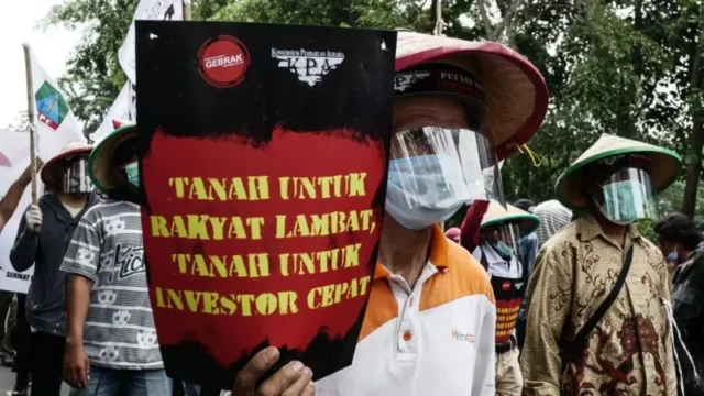 Seorang demonstran saat aksi protes terhadap UU Cipta Kerja 2020 silam membawa tuntutan reforma agraria. Sumber: Anadolu Agency via Getty Images Seorang demonstran saat aksi protes terhadap UU Cipta Kerja 2020 silam membawa tuntutan reforma agraria. Sumber: Anadolu Agency via Getty Images
