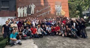 FIAD Minta Pemerintah Jamin Kesejahteraan, Kemerdekaan, dan Perlindungan Profesi Guru Puluhan peserta pertemuan FIAD berfoto bersama sambil mengepalkan tangan di depan mural Indonesia Menggugat, Bandung
