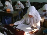Menanti Kejelasan dan Transparansi Skor TKA Siswi SMA berjilbab mengerjakan soal ujian di ruang kelas