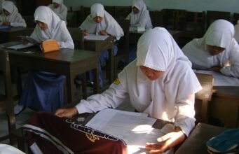 Menanti Kejelasan dan Transparansi Skor TKA Siswi SMA berjilbab mengerjakan soal ujian di ruang kelas