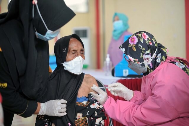 Petugas kesehatan memberikan vaksin kepada warga lansia Petugas kesehatan memberikan vaksin kepada warga lansia